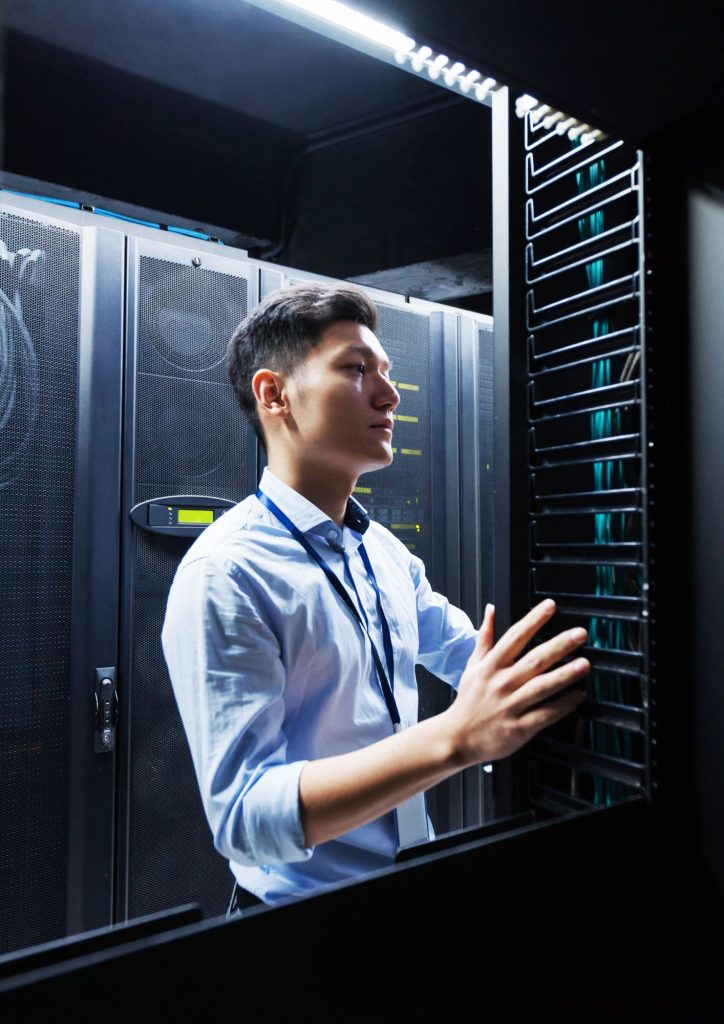 Engineer melakukan instalasi enterprise server di dalam rack server pada data center modern.